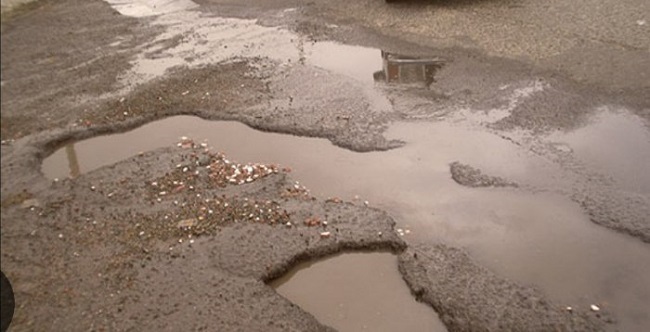 چاله های پر از آب روی آسفالت خیابان چاله های پر از آب روی آسفالت خیابان