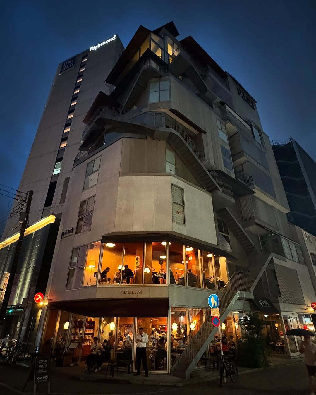 نمای ساختمان ناین آورز آساکوسا در توکیو که طی سال‌های ۲۰۱۸ تا ۲۰۲۵ از هتل کپسولی به برج سونا تغییر کاربری داده و اکنون تنها کافه نروژی FUGLEN در طبقه همکف آن فعال است؛ تصویری مرتبط با معماری و تغییرات کاربری بنا در منطقه آساکوسا.