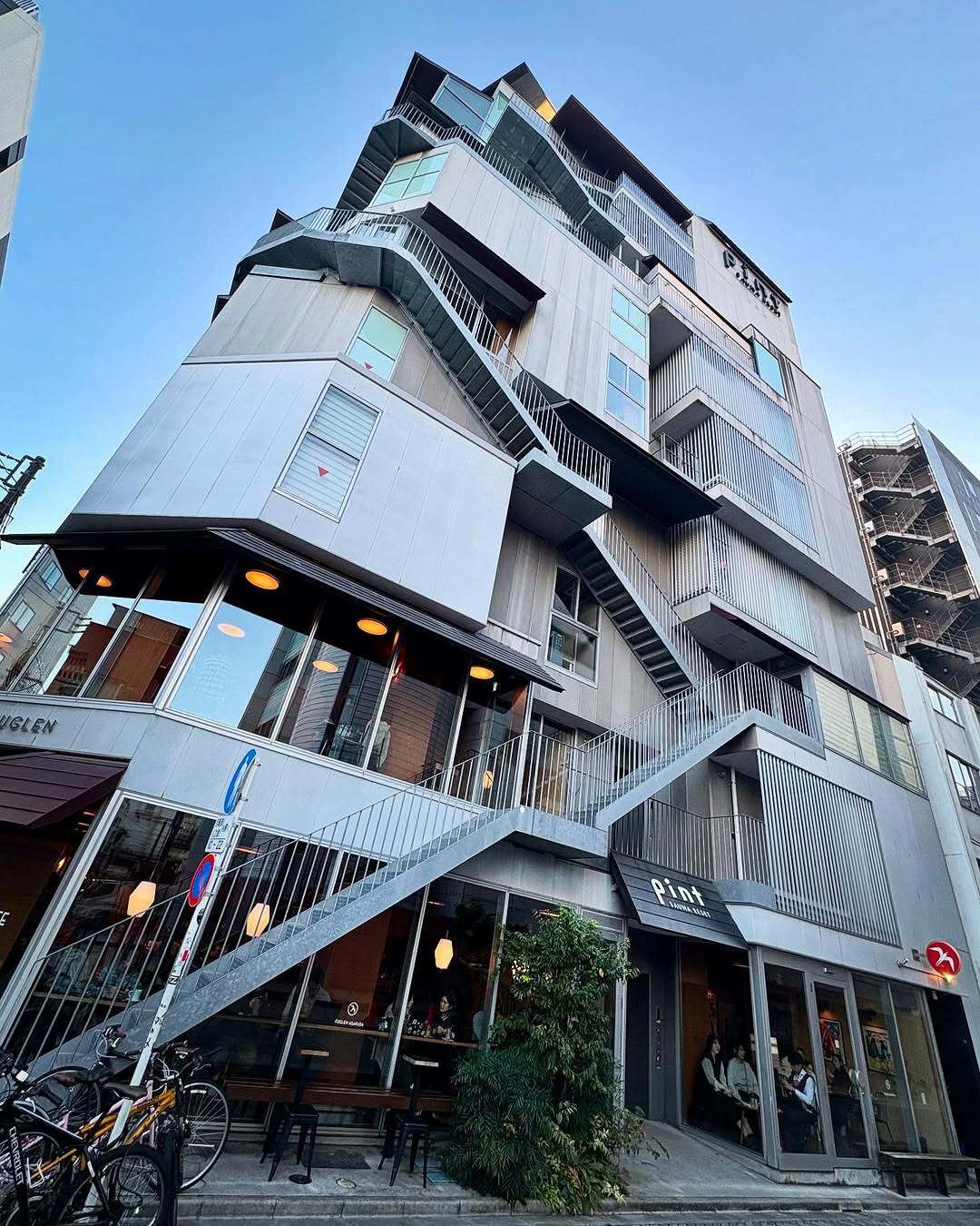 نمای ساختمان ناین آورز آساکوسا در توکیو که طی سال‌های ۲۰۱۸ تا ۲۰۲۵ از هتل کپسولی به برج سونا تغییر کاربری داده و اکنون تنها کافه نروژی FUGLEN در طبقه همکف آن فعال است؛ تصویری مرتبط با معماری و تغییرات کاربری بنا در منطقه آساکوسا.