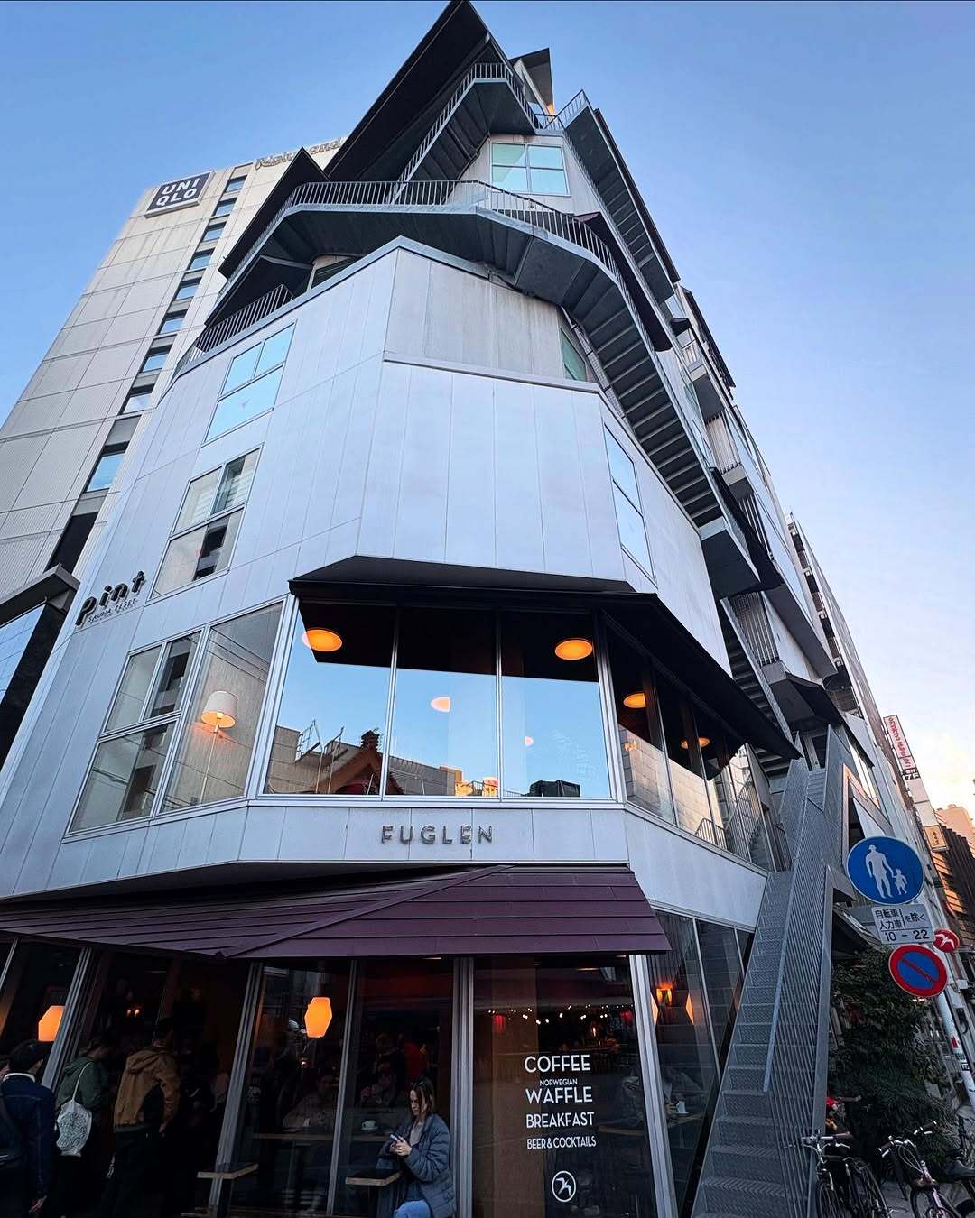 نمای ساختمان ناین آورز آساکوسا در توکیو که طی سال‌های ۲۰۱۸ تا ۲۰۲۵ از هتل کپسولی به برج سونا تغییر کاربری داده و اکنون تنها کافه نروژی FUGLEN در طبقه همکف آن فعال است؛ تصویری مرتبط با معماری و تغییرات کاربری بنا در منطقه آساکوسا.