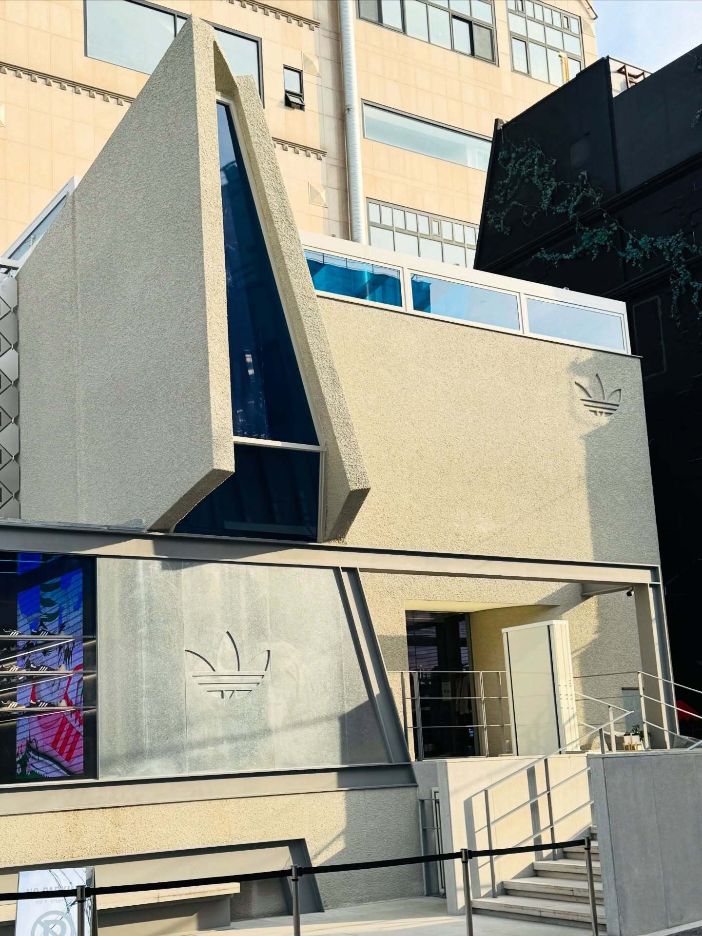 تصویری از نمای خارجی فروشگاه پرچم‌دار آدیداس اُریجینالز دوسان (Adidas Originals Flagship Dosan) در سئول کره جنوبی، ساختمانی که در اصل یک خانه مسکونی بوده و اکنون تحت بازسازی برای تبدیل کاربری به یک فضای تجاری بزرگ و مدرن برای عرضه محصولات آدیداس قرار گرفت