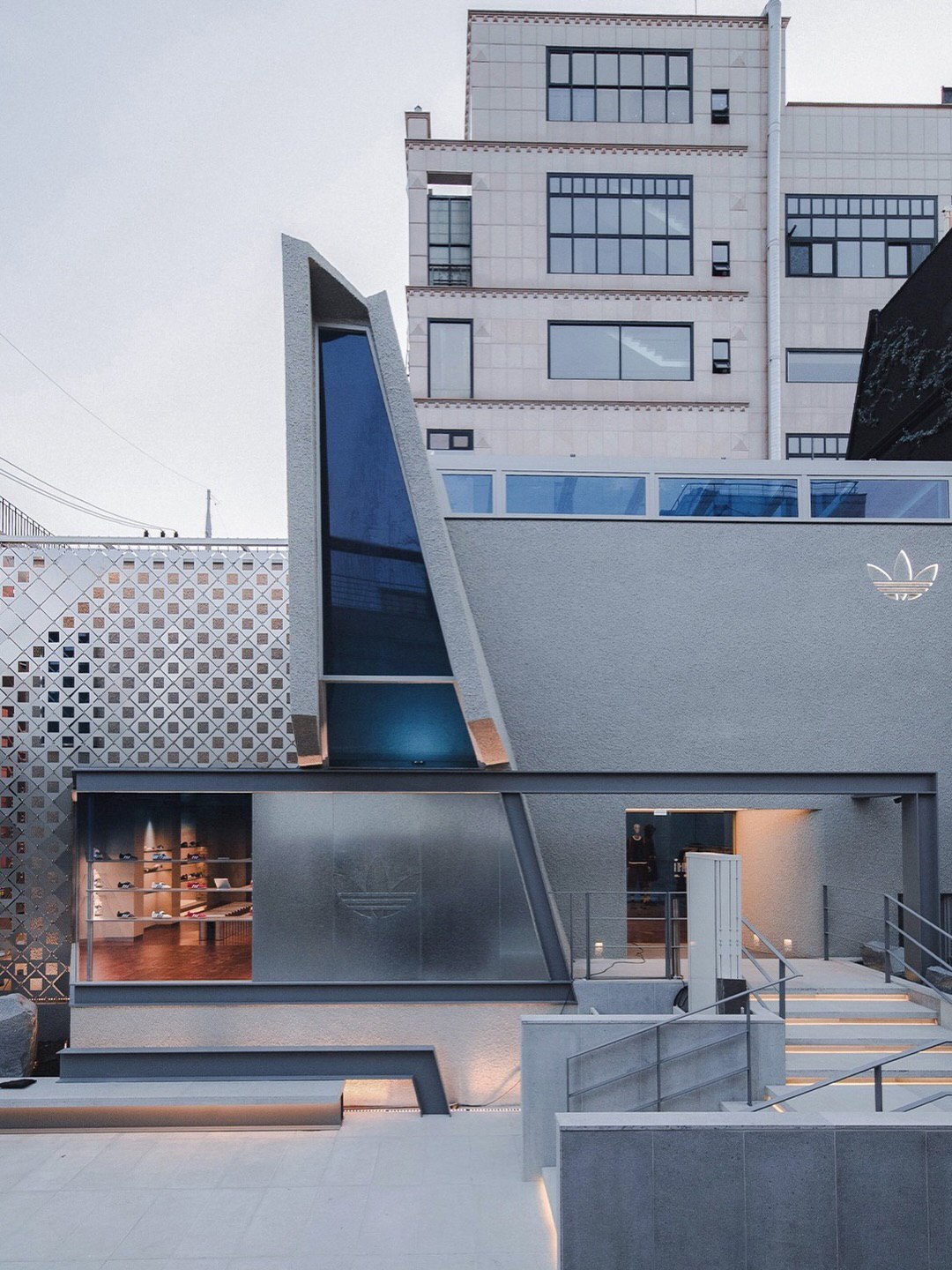 تصویری از نمای خارجی فروشگاه پرچم‌دار آدیداس اُریجینالز دوسان (Adidas Originals Flagship Dosan) در سئول کره جنوبی، ساختمانی که در اصل یک خانه مسکونی بوده و اکنون تحت بازسازی برای تبدیل کاربری به یک فضای تجاری بزرگ و مدرن برای عرضه محصولات آدیداس قرار گرفت