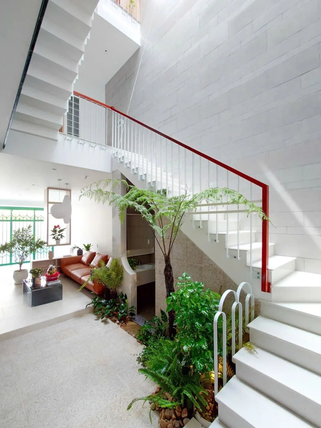 نمای خارجی و داخلی خانه چهار طبقه «شهر غربی» (Casa Cidade do Oeste) در ویتنام با مساحت ۹۰ متر مربع، که طراحی آن شامل نمای ساده، لایههای انبوه گیاهی برای حفظ حریم خصوصی، و فضاهای داخلی پلان باز با نورگیر مرکزی برای ایجاد محیطی آرام و روشن است. نمای خارجی و داخلی خانه چهار طبقه «شهر غربی» (Casa Cidade do Oeste) در ویتنام با مساحت ۹۰ متر مربع، که طراحی آن شامل نمای ساده، لایههای انبوه گیاهی برای حفظ حریم خصوصی، و فضاهای داخلی پلان باز با نورگیر مرکزی برای ایجاد محیطی آرام و روشن است.