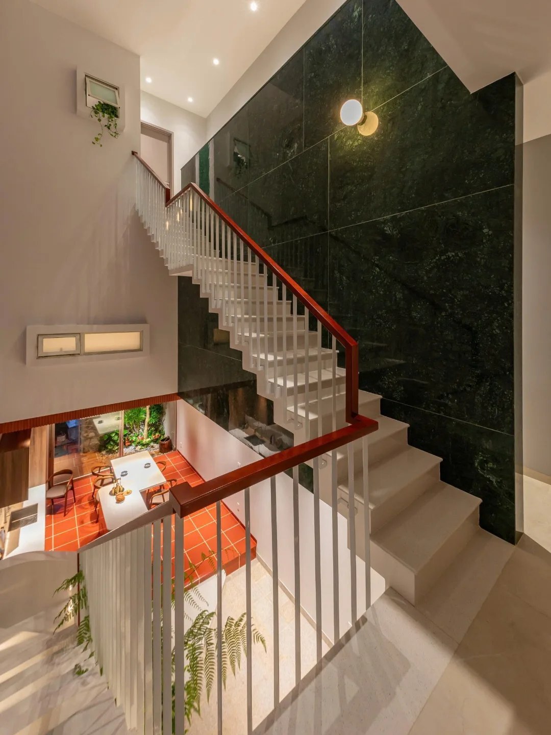 نمای خارجی و داخلی خانه چهار طبقه «شهر غربی» (Casa Cidade do Oeste) در ویتنام با مساحت ۹۰ متر مربع، که طراحی آن شامل نمای ساده، لایه‌های انبوه گیاهی برای حفظ حریم خصوصی، و فضاهای داخلی پلان باز با نورگیر مرکزی برای ایجاد محیطی آرام و روشن است.