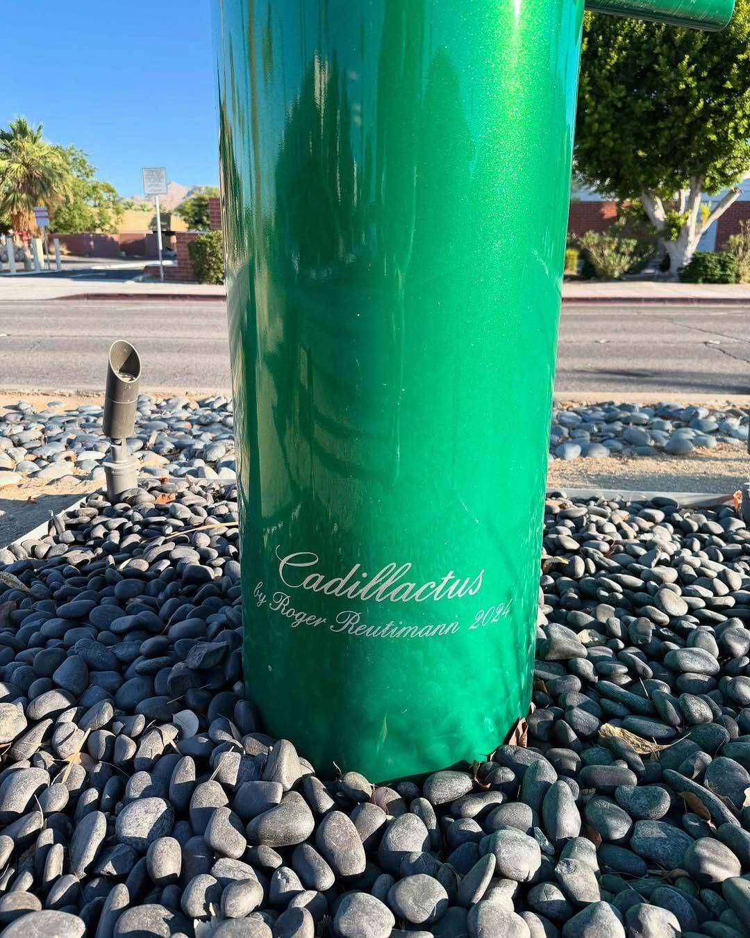 مجسمه بزرگ و سبزرنگ به شکل کاکتوس که از باله‌های عقب (Tailfins) خودروهای کلاسیک کادیلاک دهه ۱۹۵۰ و ۱۹۶۰ الهام گرفته شده، و کلمه Creativity (خلاقیت) روی بدنه آن نوشته شده است؛ این اثر هنری در یک محیط بیابانی با درختان نخل و کوه‌های پس‌زمینه قرار دارد.