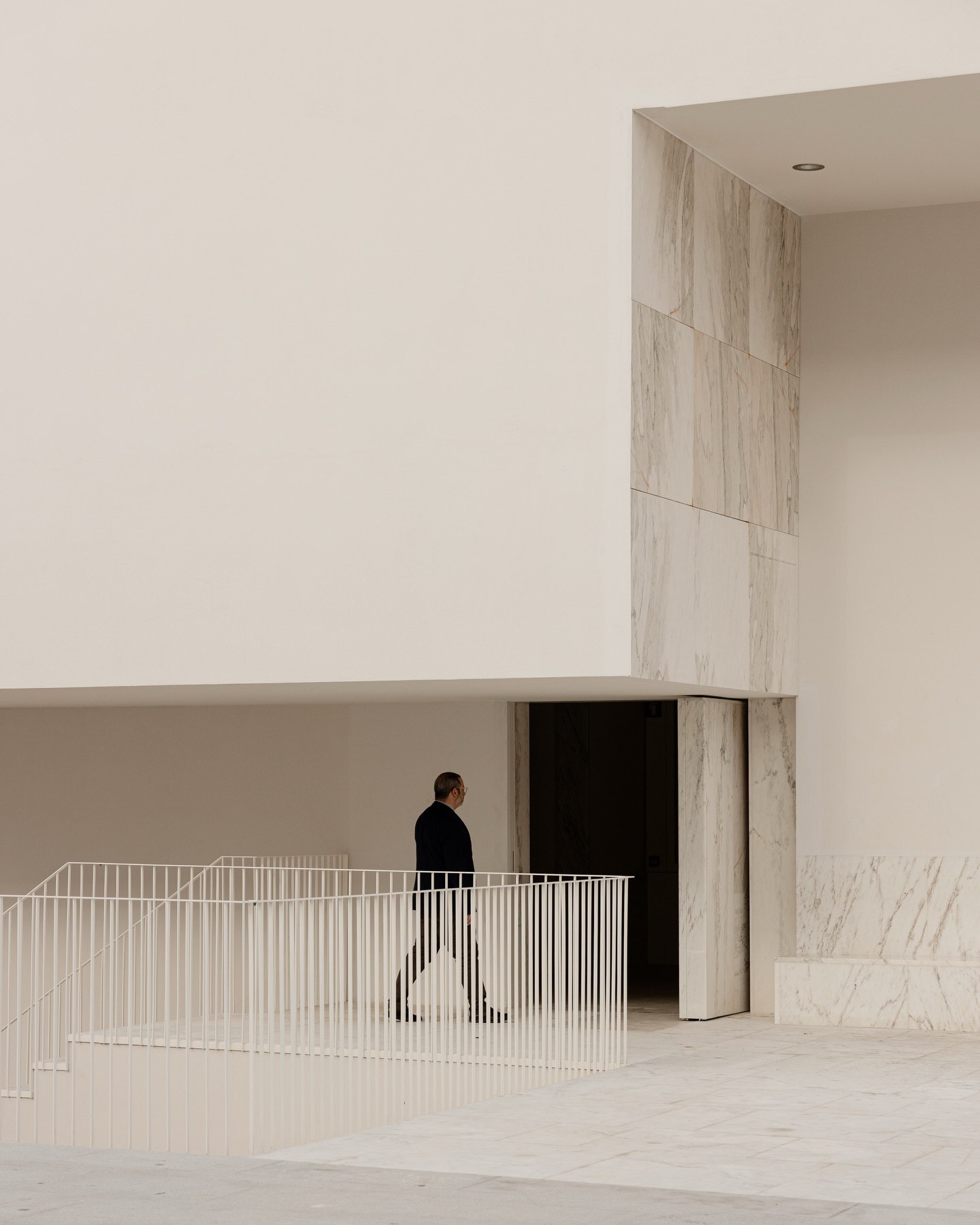 تصویری از نمای داخلی یا بیرونی کلیسای سائو ژوزه دابوآویستا (The Church of São José da Boavista) در پرتغال، با معماری مینیمالیستی نرم و مدرن، که توسط آتلیه بوگیو و ماتوس گامیرو آرکیتکتوس طراحی شده است. تأکید این تصویر بر خطوط تمیز، حجم‌های هندسی ساده و نور