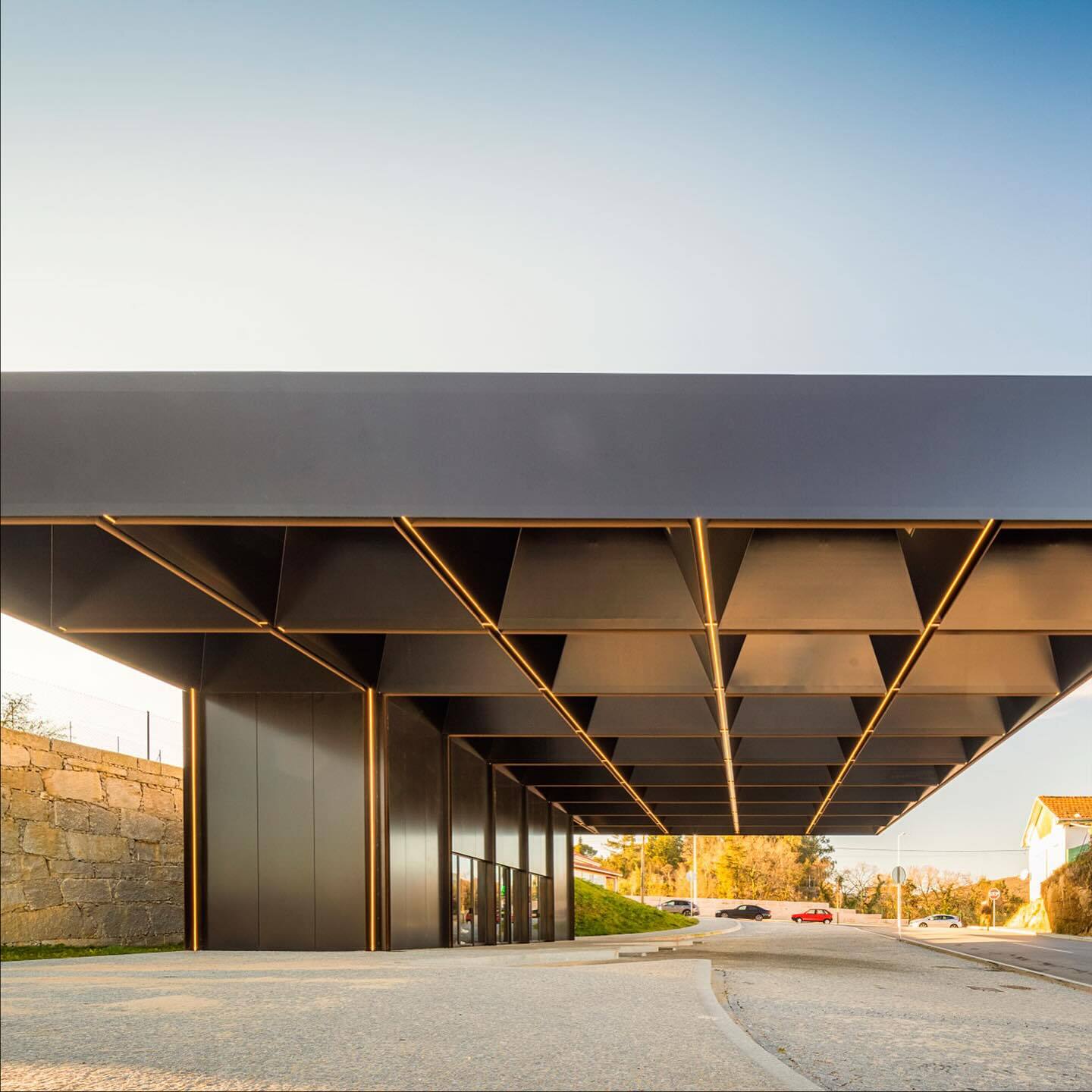 تصویری از نمای خارجی مرکز چندوجهی (Intermodal Center) در لوزادا، واقع در شمال شرقی پورتو پرتغال، که توسط شرکت معماری Spaceworkers طراحی شده است. این ساختمان با حجم‌های هندسی خاص و مدرن و استفاده از مصالح سفید یا روشن، به عنوان یک نشانه‌ی شهری و قطب جدید فرهنگی و حمل‌ونقل در منطقه عمل می‌کند.