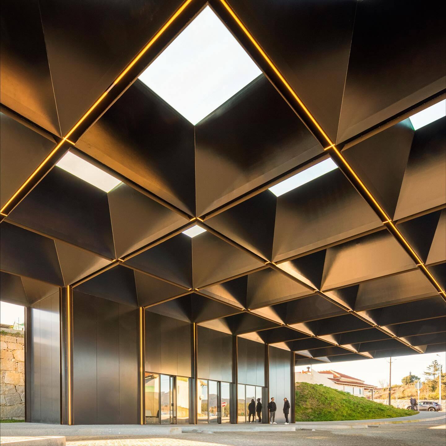 تصویری از نمای خارجی مرکز چندوجهی (Intermodal Center) در لوزادا، واقع در شمال شرقی پورتو پرتغال، که توسط شرکت معماری Spaceworkers طراحی شده است. این ساختمان با حجم‌های هندسی خاص و مدرن و استفاده از مصالح سفید یا روشن، به عنوان یک نشانه‌ی شهری و قطب جدید ف