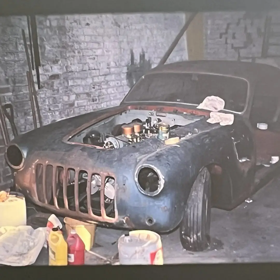 نمای کناری خودروی کلاسیک سیزیتالیا ۸۰۸XF مدل ۱۹۵۲ به رنگ آبی متالیک با طراحی بدنه گیا و رینگ‌های کلاسیک کرومی در فضای باز.