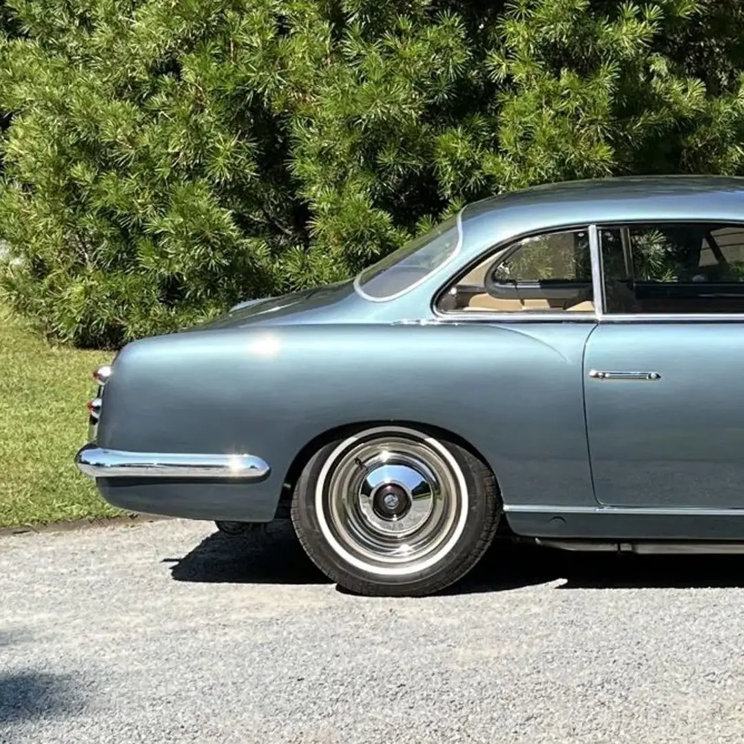 نمای کناری خودروی کلاسیک سیزیتالیا ۸۰۸XF مدل ۱۹۵۲ به رنگ آبی متالیک با طراحی بدنه گیا و رینگ‌های کلاسیک کرومی در فضای باز.