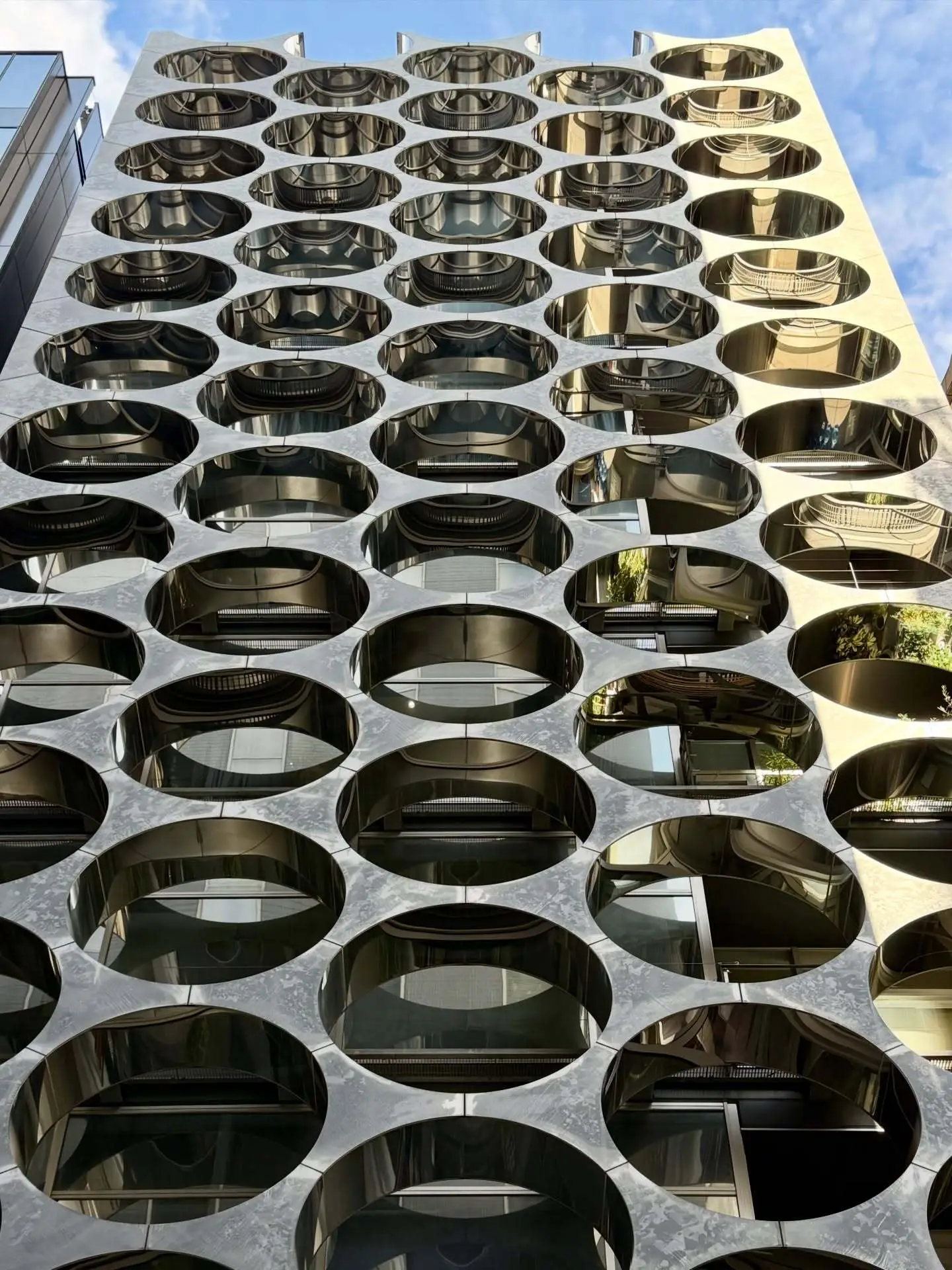 نمای خارجی ساختمان آلفا ماتریکس در توکیو اثر تاکتو شیموهیگوشی، با قاب‌های فلزی مستطیلی و پنل‌های شیشه‌ای مدرن در منطقه گینزا.