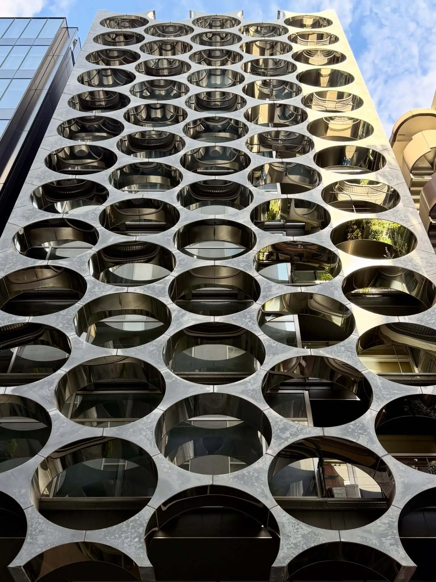 نمای خارجی ساختمان آلفا ماتریکس در توکیو اثر تاکتو شیموهیگوشی، با قاب‌های فلزی مستطیلی و پنل‌های شیشه‌ای مدرن در منطقه گینزا.