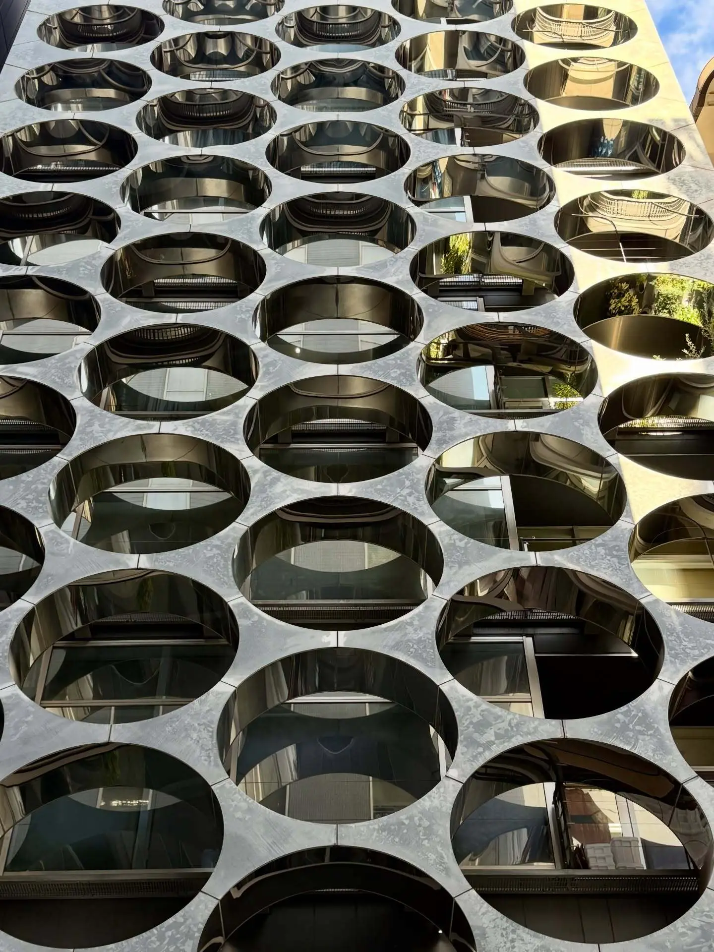 نمای خارجی ساختمان آلفا ماتریکس در توکیو اثر تاکتو شیموهیگوشی، با قاب‌های فلزی مستطیلی و پنل‌های شیشه‌ای مدرن در منطقه گینزا.