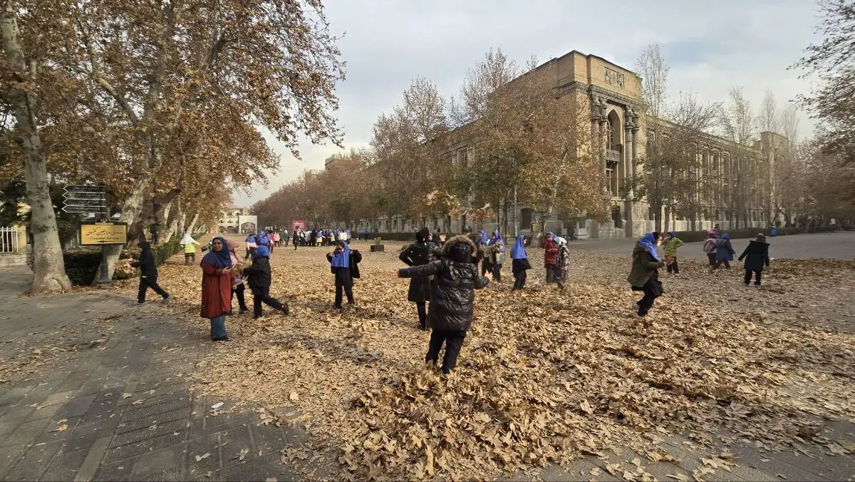 یک گروه از دختران دانش‌آموز با برگ‌ها، برگ‌بازی می‌کنند