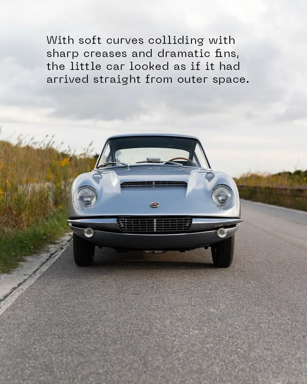 نمای نزدیک از طراحی آیرودینامیک و بدنه مجسمه‌گونه یک خودروی کلاسیک برتونه متعلق به اواخر دهه ۱۹۵۰ با باله‌های نمادین و خطوط تیز بدنه.