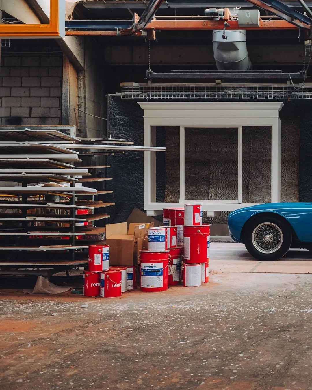 نمای جلویی و جانبی خودروی کلاسیک مازراتی A6GCS فارینا برلینتا به رنگ آبی متالیک با رینگ‌های پره‌ای در مقابل یک بنای سنتی اروپایی.