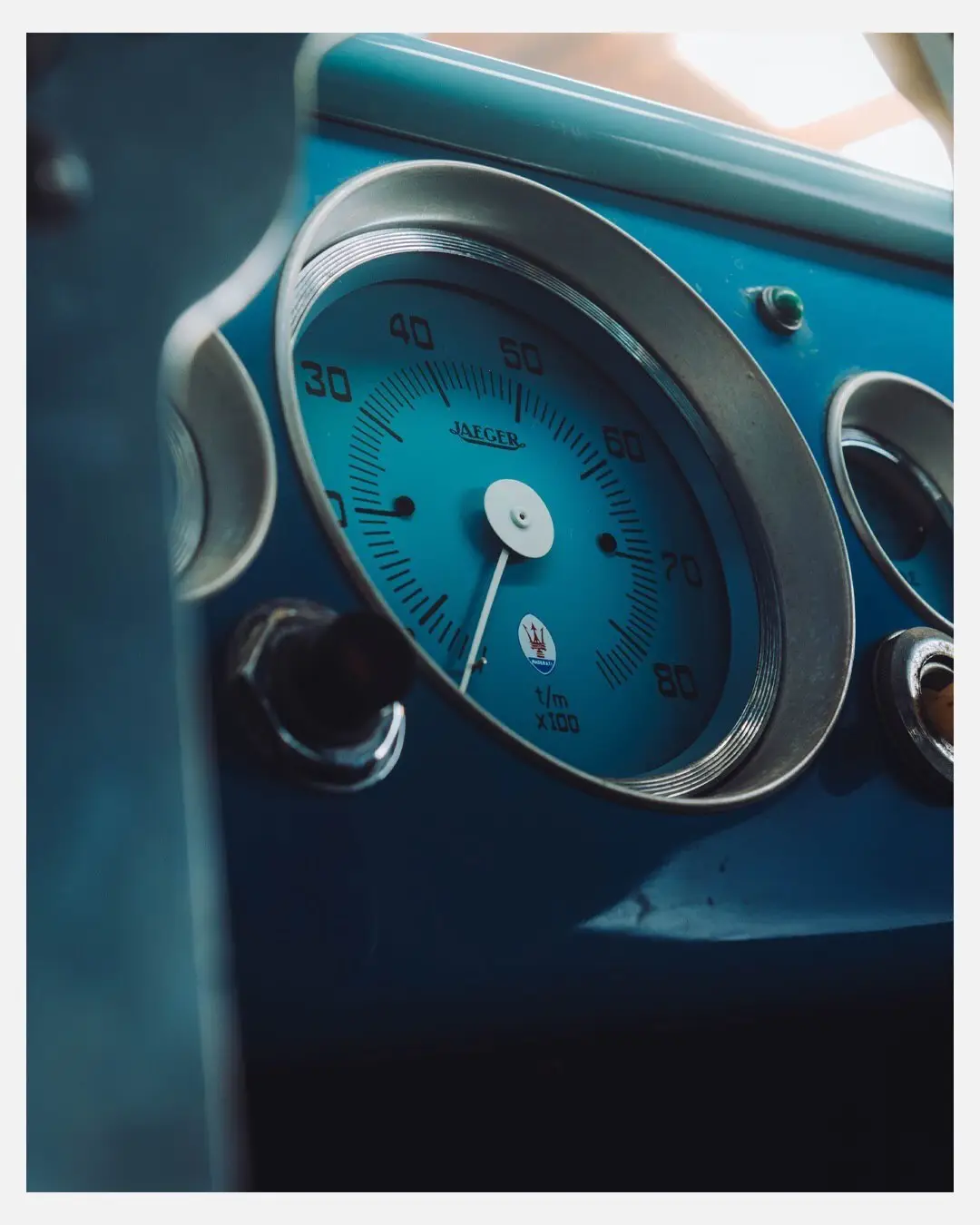 نمای جلویی و جانبی خودروی کلاسیک مازراتی A6GCS فارینا برلینتا به رنگ آبی متالیک با رینگ‌های پره‌ای در مقابل یک بنای سنتی اروپایی.