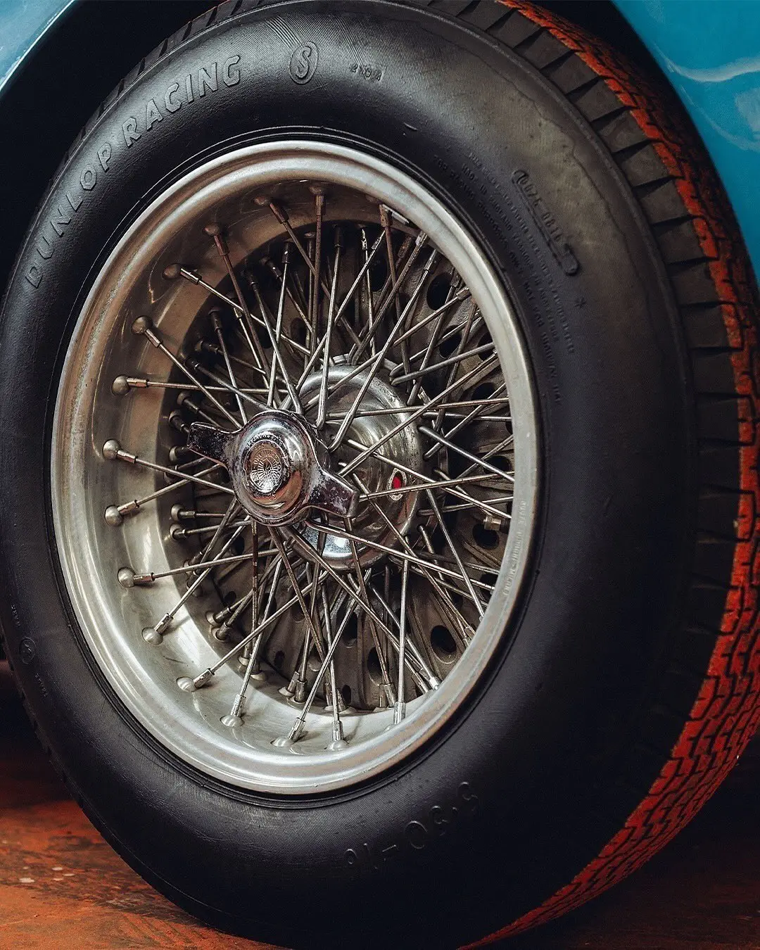 نمای جلویی و جانبی خودروی کلاسیک مازراتی A6GCS فارینا برلینتا به رنگ آبی متالیک با رینگ‌های پره‌ای در مقابل یک بنای سنتی اروپایی.