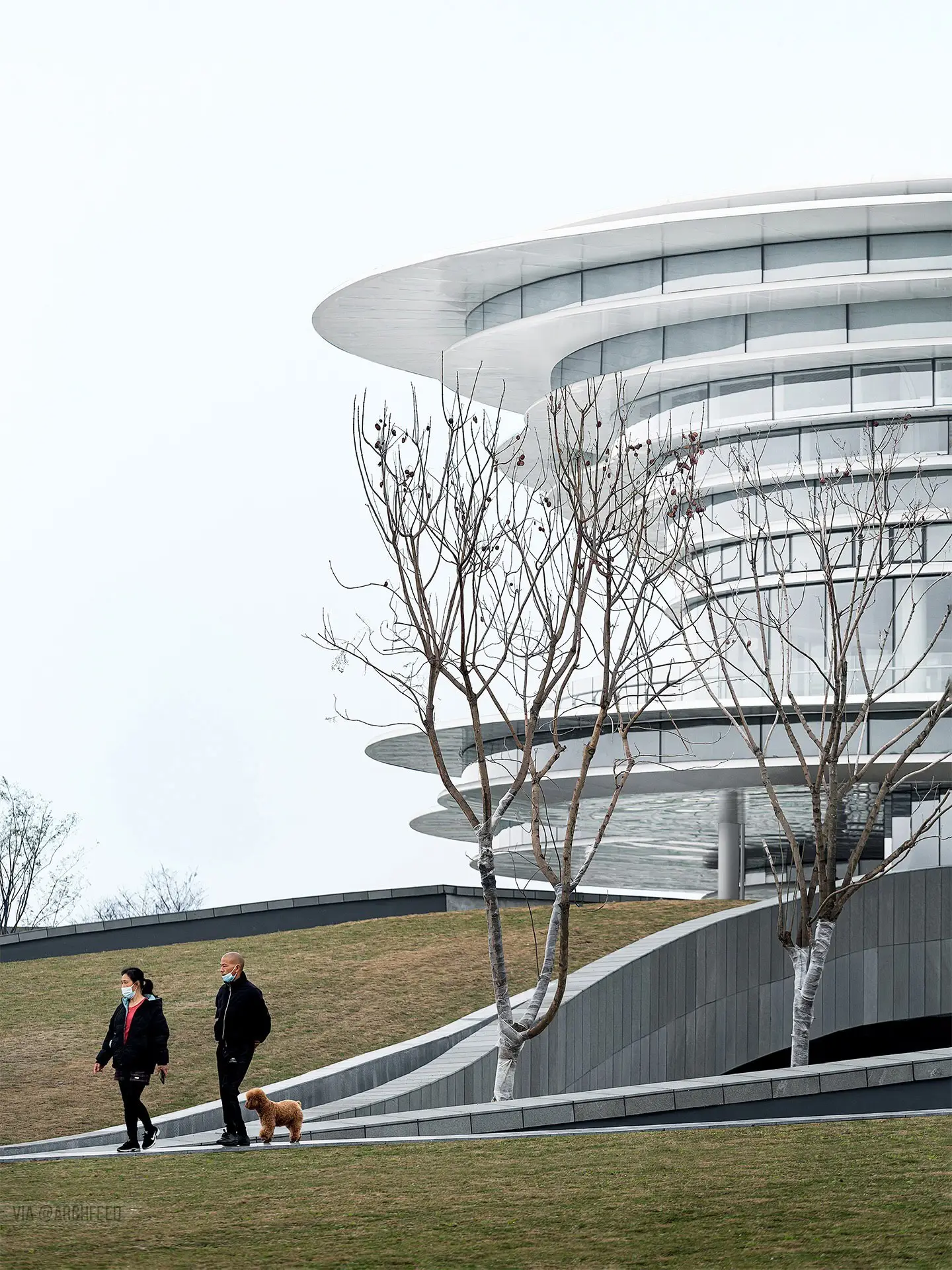 نمای ساختمان مدرن و معلق مرکز نمایشگاهی ابر فرودگاه چنگدو با طراحی سفید و کشیده بر فراز فضای سبز که نشان‌دهنده سبک معماری انتزاعی شرکت CSWADI است.