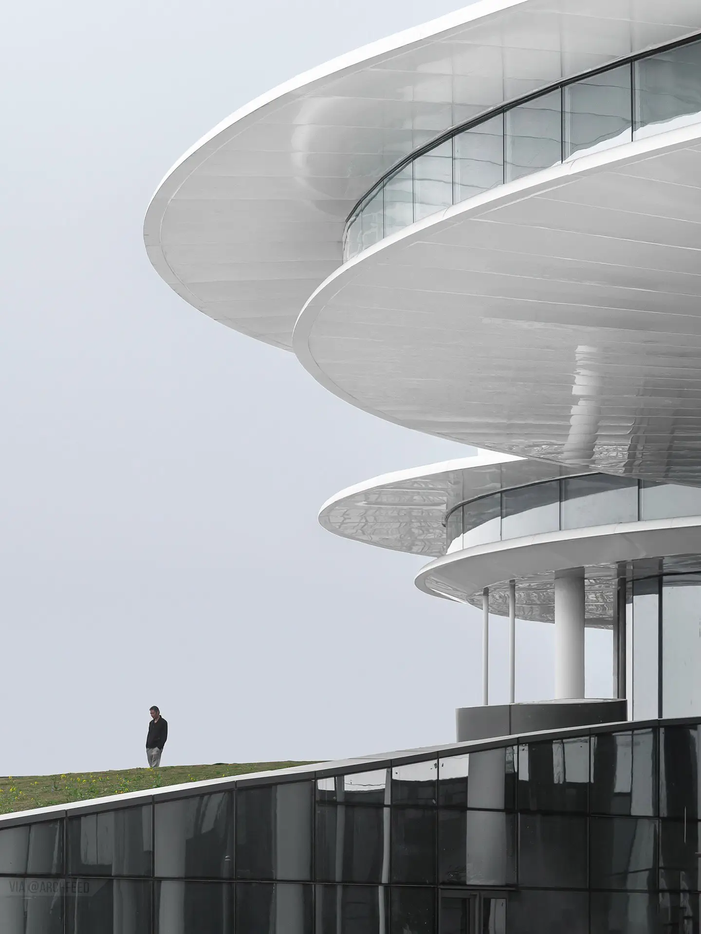 نمای ساختمان مدرن و معلق مرکز نمایشگاهی ابر فرودگاه چنگدو با طراحی سفید و کشیده بر فراز فضای سبز که نشان‌دهنده سبک معماری انتزاعی شرکت CSWADI است.