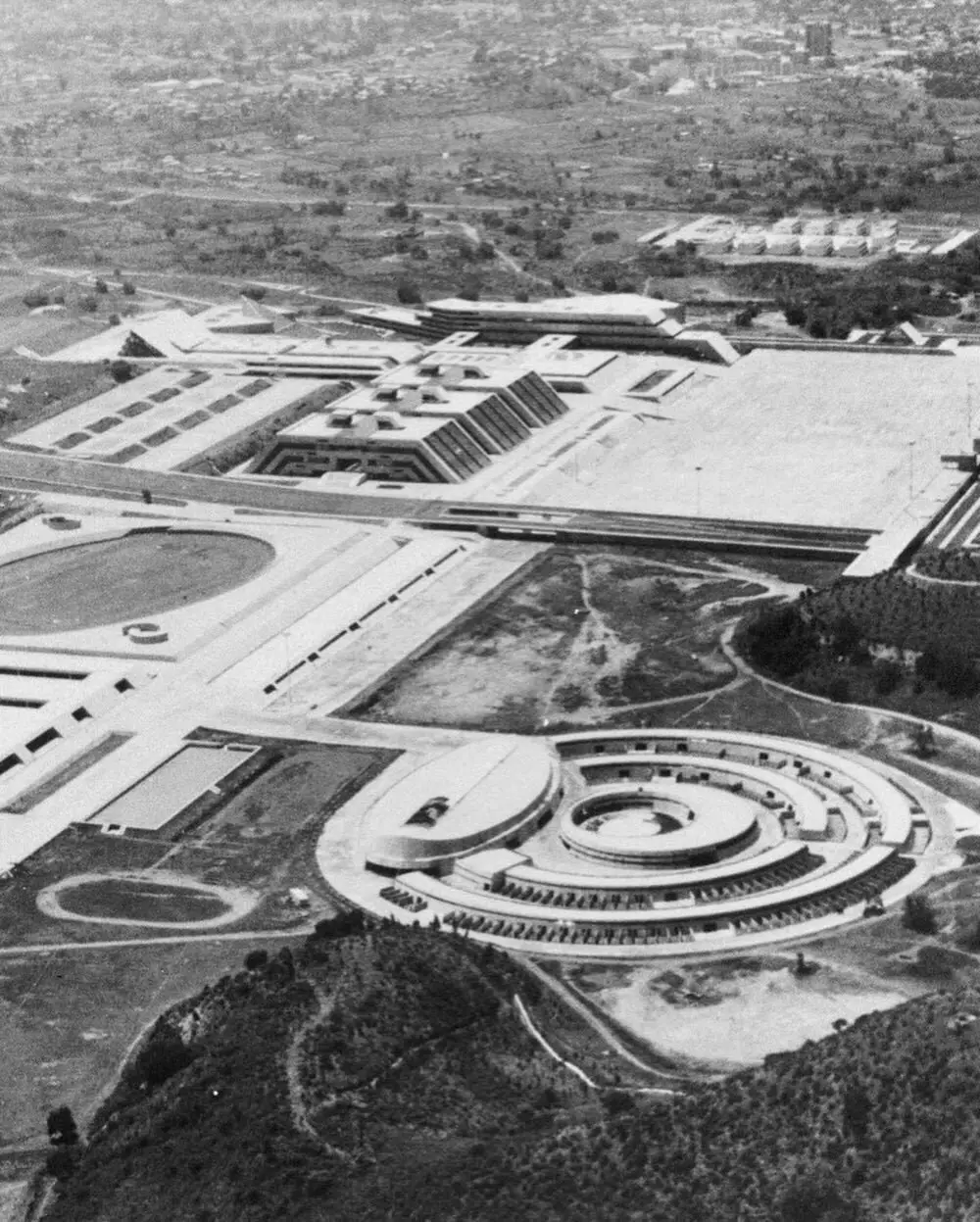 نمای ساختمان‌های بتنی به سبک بروتالیسم در مکزیک با هندسه صلب و سایه‌های عمیق که نشان‌دهنده ترکیب معماری مدرن و سنتی است.