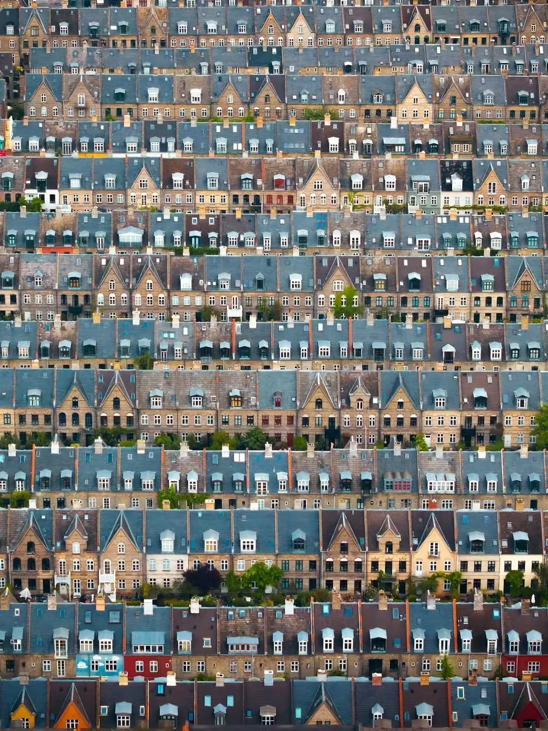 تصویر هوایی از ردیف‌های منظم خانه‌های تاریخی آجری با سقف‌های شیب‌دار در محله پوتیتورکنه کپنهاگ.