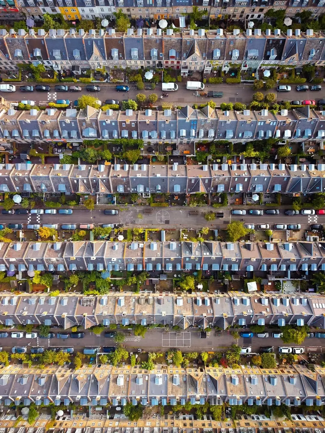 تصویر هوایی از ردیف‌های منظم خانه‌های تاریخی آجری با سقف‌های شیب‌دار در محله پوتیتورکنه کپنهاگ.