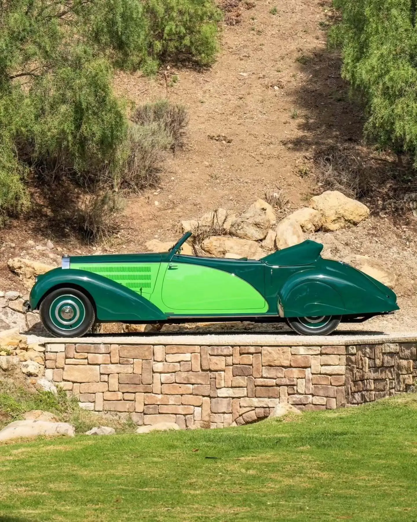 نمای جانبی خودروی کلاسیک بوگاتی تایپ ۵۷ به رنگ سبز تیره (Christmas Tree Green) در فضای نمایشگاهی حراجی ساتبیز.