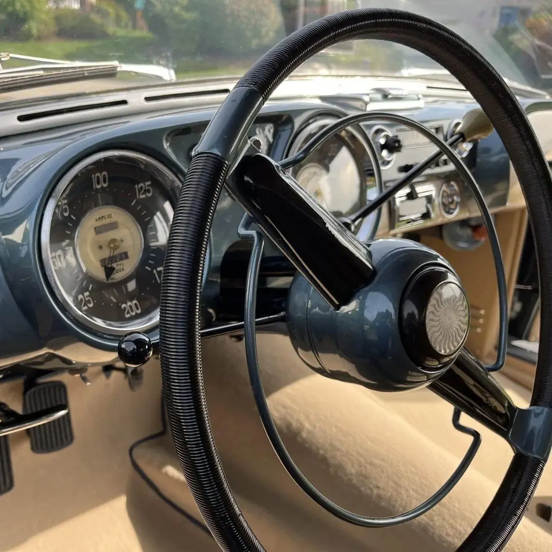 نمای کناری خودروی کلاسیک سیزیتالیا ۸۰۸XF مدل ۱۹۵۲ به رنگ آبی متالیک با طراحی بدنه گیا و رینگ‌های کلاسیک کرومی در فضای باز.