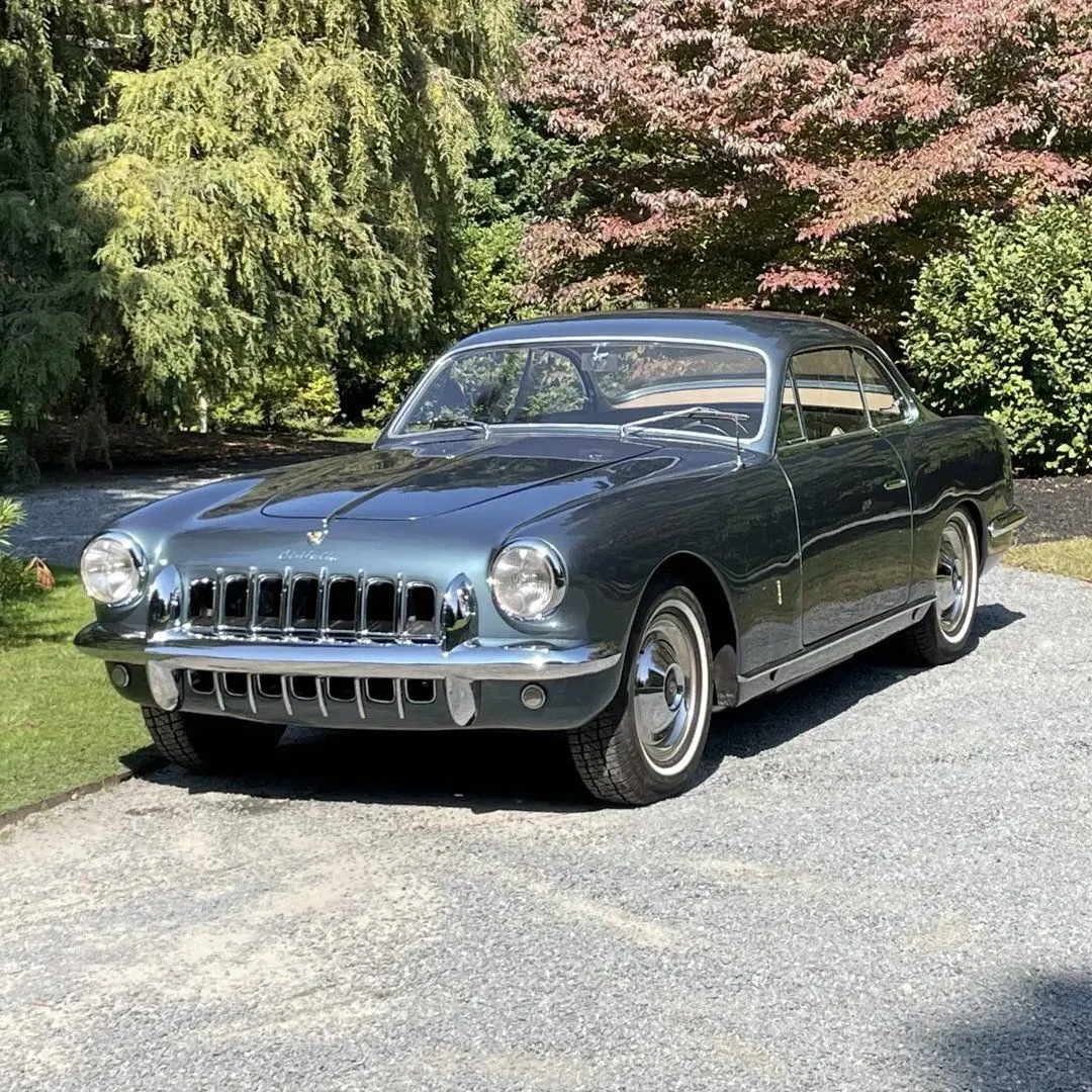 نمای کناری خودروی کلاسیک سیزیتالیا ۸۰۸XF مدل ۱۹۵۲ به رنگ آبی متالیک با طراحی بدنه گیا و رینگ‌های کلاسیک کرومی در فضای باز.