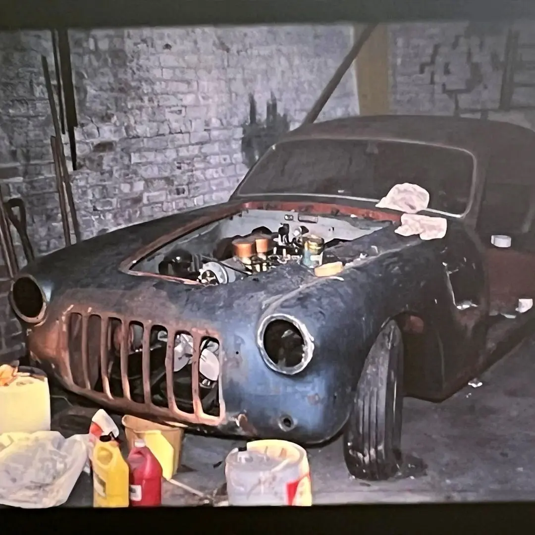 نمای کناری خودروی کلاسیک سیزیتالیا ۸۰۸XF مدل ۱۹۵۲ به رنگ آبی متالیک با طراحی بدنه گیا و رینگ‌های کلاسیک کرومی در فضای باز.