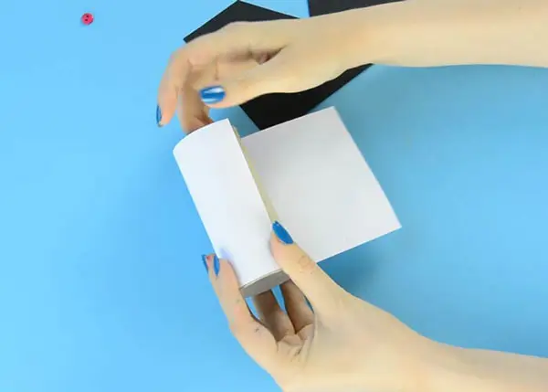 چسباندن کاغذ سفید به رول مقوایی برای ساخت کاردستی برای روز پدر